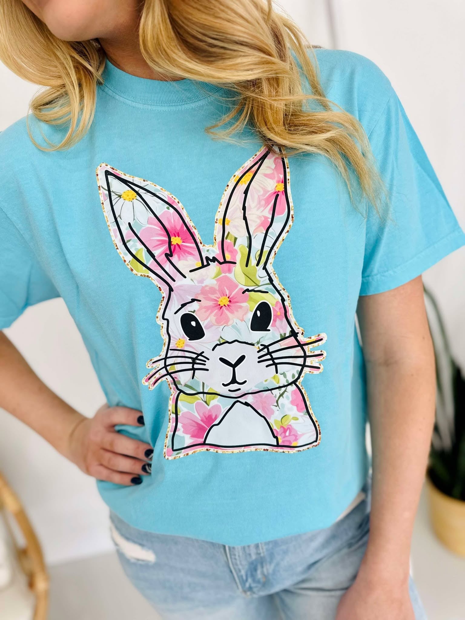 Person wearing a blue t-shirt with a colorful bunny design.