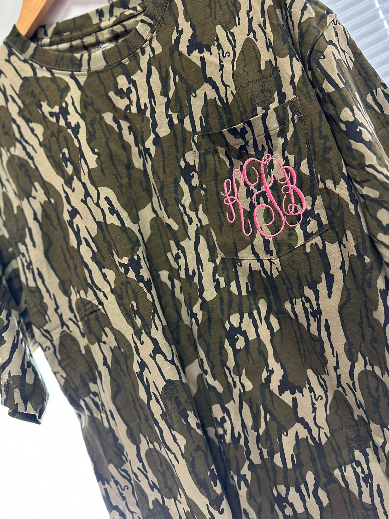 Camouflage dress with pink monogram on a hanger