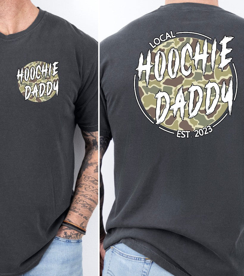 A graphic tee with 'HOOCHIE DADDY' printed on the front and a camouflage pattern on the back, available in a color named 'Pepper'.
