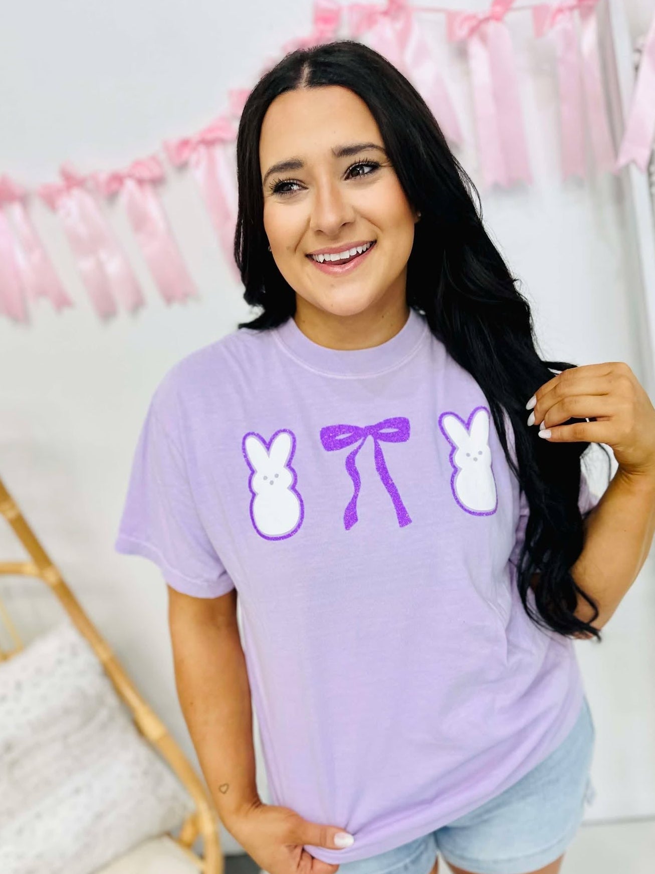 Woman wearing a purple t-shirt with graphic designs in a home setting