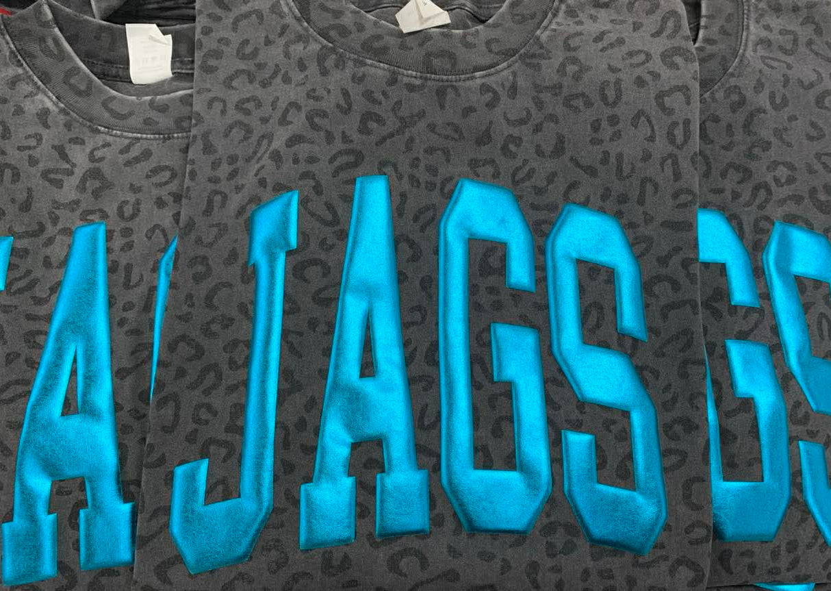 Gray sweatshirt with blue 'JAGS' Puff vinyl on a black leopard tee background