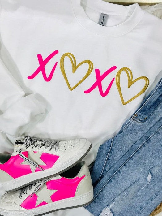 A white sweatshirt with 'XOXO' and heart vinyl designs, paired with blue denim jeans and white sneakers with pink accents.